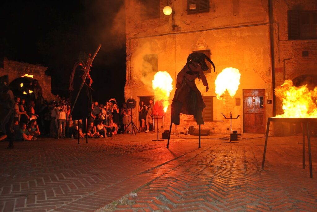 Trampolista vestito da mostro con fuoco dietro