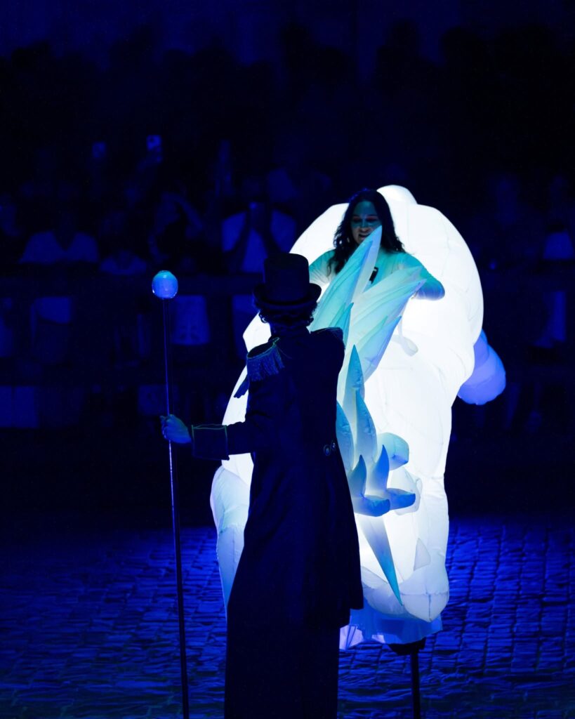 Tamer giving instructions to a glowing unicorn on stilts