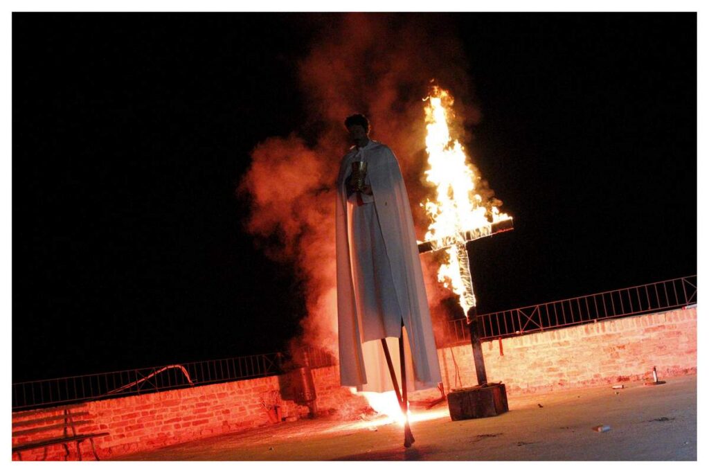 Knight errant with a flaming cross behind him
